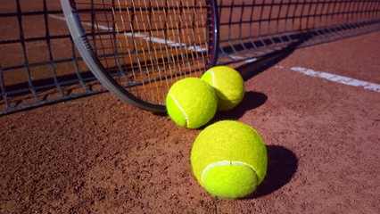 Tennisschl&auml;ger mit Tennisb&auml;llen auf einem Tennisplatz