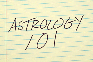 The words "Astrology 101" on a yellow legal pad