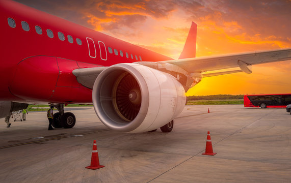 Fototapeta airplane ready for boarding in a airport hub at sunset