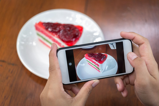 Taking photo of cake on wooden table.