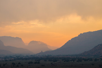 Smokey sunrise in the desert mountain layers