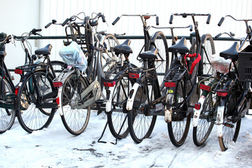 Bikes parked in winter snow in Amsterdam, Netherlands.