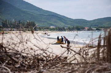 Vietnamese fishermen, sailed to shore with a catch.