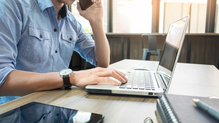 Portrait of businessman talking on mobile phone in office