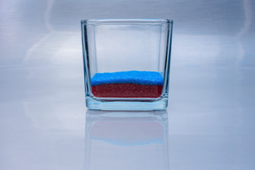 Glass with sprinkles on reflective background