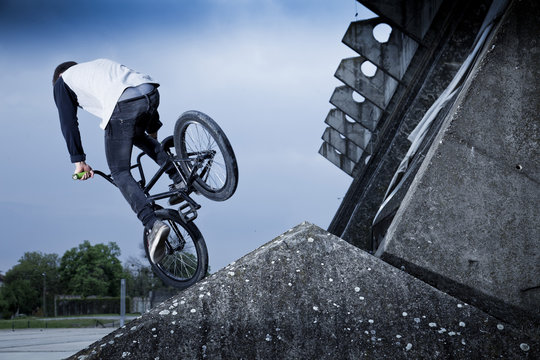 BMX biker performing a stunt on a bridge