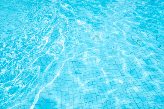 Blue waves water in swimming pool and sun bright. concept color summer.