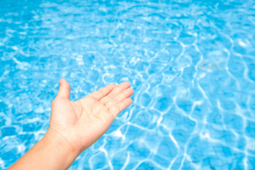 Concept of holiday tropical on summer, Blue wave pool and hand of a woman. For product display montage or design layout.