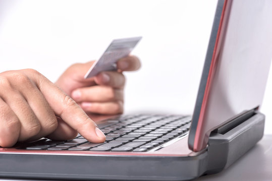 Hands holding credit card and using laptop computer