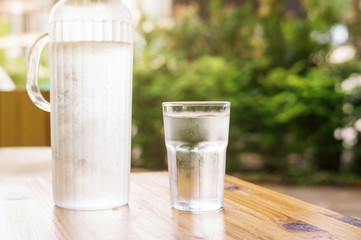 a glass of water on a wooden table.