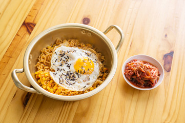 egg instant noodle and kimchi on a wooden table.