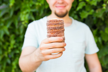 Close-up of tourist holds in hand Trdlo or Trdelnik background. Fresh Appetizing Trdlo or Trdelnik - Traditional National Czech Sweet Pastry Dough.