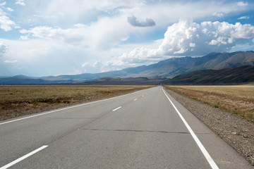 Asphalt winding road in the mountainous area in the summer and sky with clouds