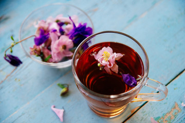 cup of tea with chamomile flowers on rustic wooden background