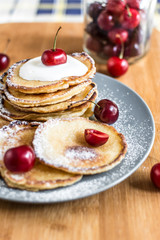 Sweet pancakes with berries and fruits on a wooden background