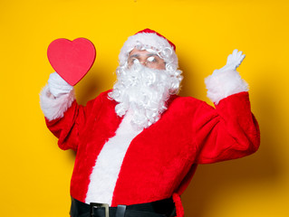 Santa Claus holding heart shape gift