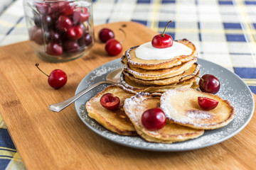 Sweet pancakes with berries and fruits on a wooden background