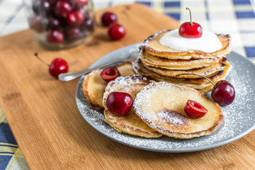 Sweet pancakes with berries and fruits on a wooden background