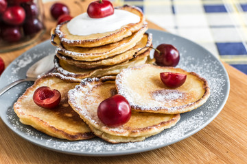 Sweet pancakes with berries and fruits on a wooden background
