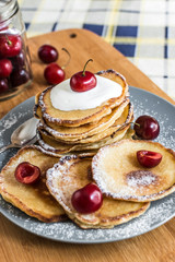 Sweet pancakes with berries and fruits on a wooden background