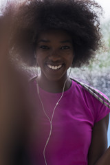 portrait of young afro american woman in gym while listening music