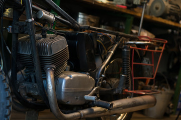 Fototapeta premium Old vintage motorcycle, which needs to be repaired, in the workshop