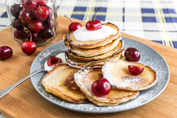 Sweet pancakes with berries and fruits on a wooden background
