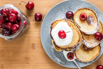 Sweet pancakes with berries and fruits on a wooden background