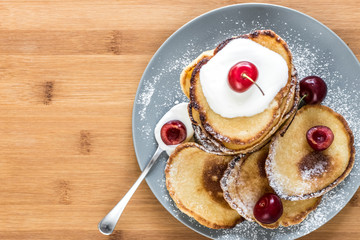 Sweet pancakes with berries and fruits on a wooden background