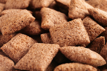 Chocolate pads corn flakes closeup background. Cereals texture.