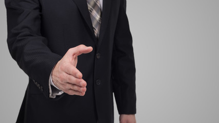 Businessman giving his hand for handshake to partner