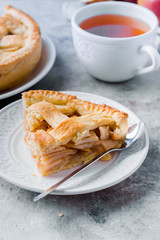 Popular American apple pie and cup of tea on gray table. Homemade classical friut tart. Copy space
