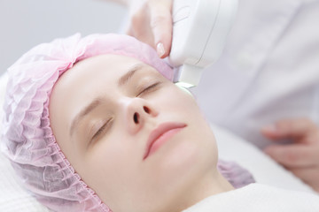 Fototapeta na wymiar Woman getting laser face treatment in medical spa center