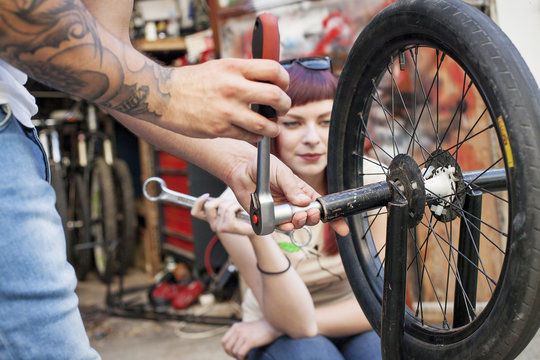 Young couple in workshop repairing BMW bicycle