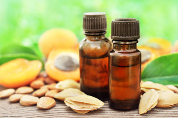 Apricot kernel oil on pits, stones and fresh apricots background