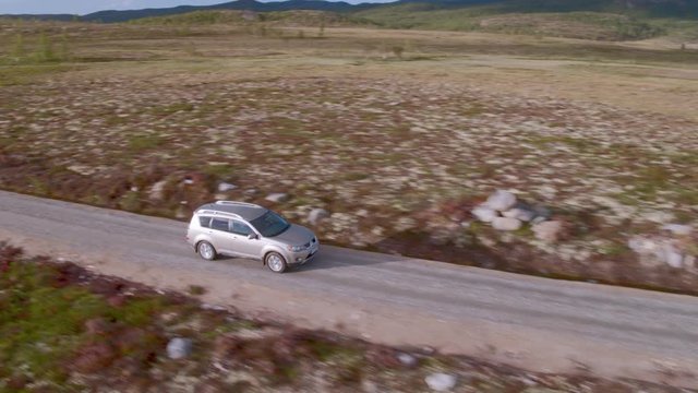 Car driving on rural road over marshlands