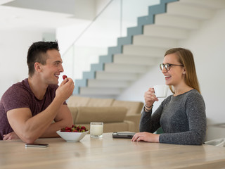 couple enjoying morning coffee and strawberries