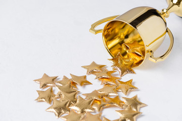 Golden trophy cup with golden stars on white textured background