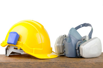 Hard hat helmet and gas respirator isolated on table