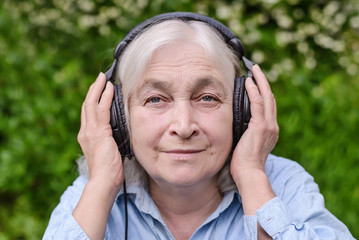 Elderly woman listening to music on headphones