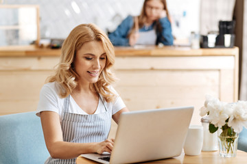 Attractive young woman typing a message on laptop