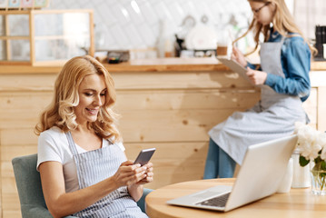 Beautiful woman sending text messages in cafe