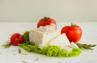 Lettuce leaves, cherry tomatoes, broccoli and tofu on white background.