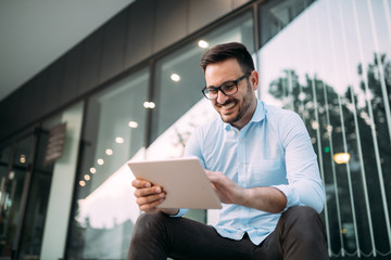 Portrait of businessman in glasses holding tablet