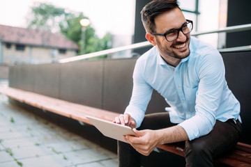 Portrait of businessman in glasses holding tablet