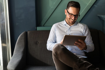Portait of businessman in glasses holding tablet