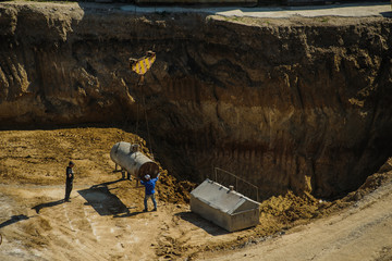 workers at a construction site moving a metal barrel