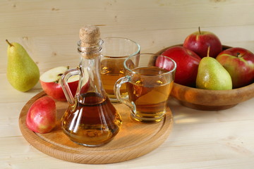 Apple cider and fruit on wooden background.