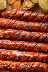 Grilled sausages in oven pan with garlic and onion