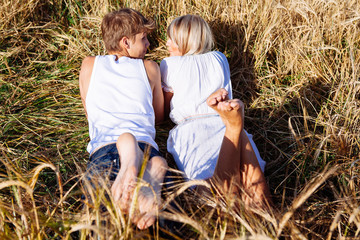 Feet of young man and woman on wheat field